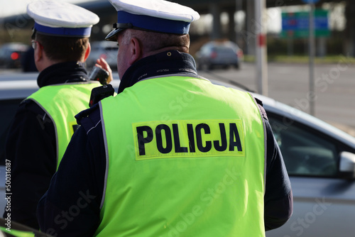  Policjant policji drogowej podczas kierowania ruchem z lizakiem do zatrzymywania pojazdów.