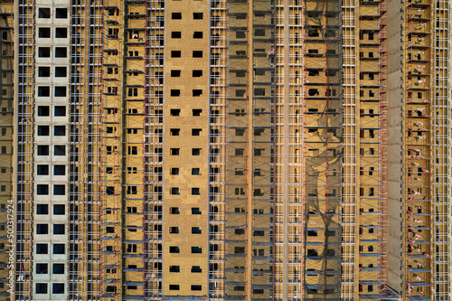 unfinished building under construction empty windows concrete apartment building in metropolis. High quality photo