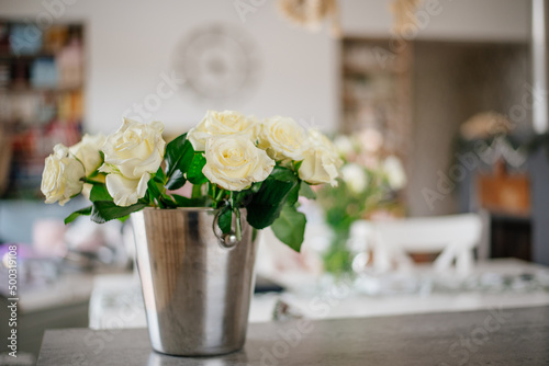 Białe róże na stole w nowoczesnym wnętrzu photo