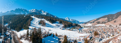 Panoramic view of snow mountain and townscape in south tyrol. Scenic white landscape against clear blue sky. Beautiful scenery on sunny day during winter.