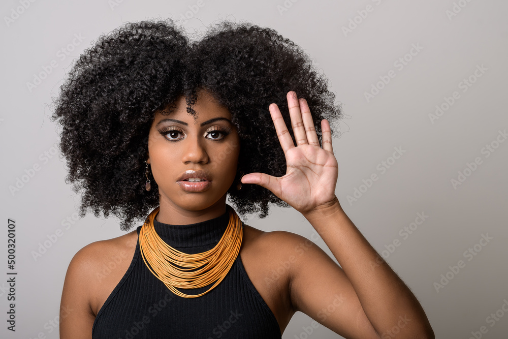 black woman makes gesture with open hand, denounces assault, moral harassment, cowardice, violence against women, isolated on gray background black woman makes gesture with open hand, denounces assault, moral harassment, cowardice, violence against women, isolated on gray background