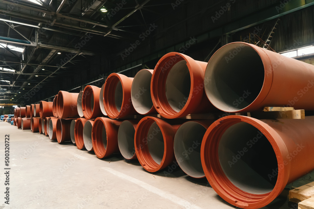 New cast and painted iron pipes for wastewater pipeline construction in warehouse storage. New cast and painted iron pipes for wastewater pipeline construction in warehouse storage.