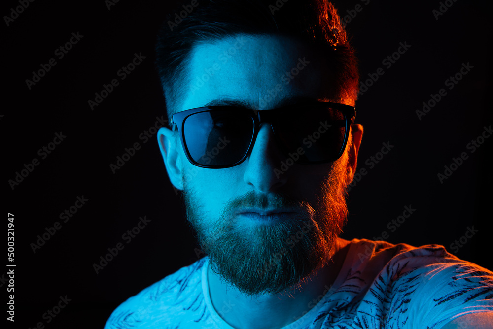 Fototapeta premium Man in sunglasses in neon light