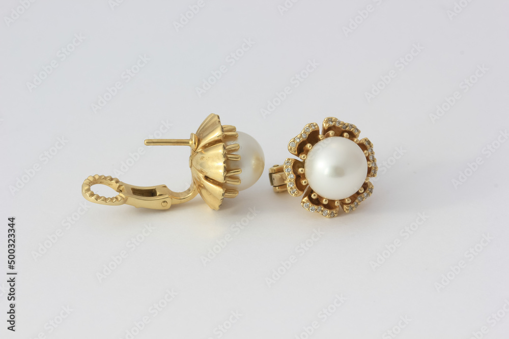 Close-up photo of white pearl earrings with diamonds in gold Close-up photo of white pearl earrings with diamonds in gold
