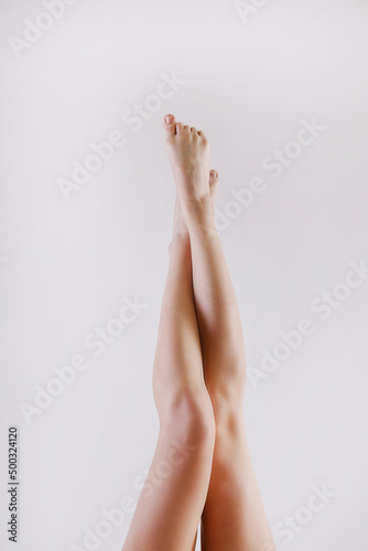Cropped shot of woman's legs after body hair removal procedures. Unrecognizable woman showing her calves over isolated white background. Copy space for text, close up.