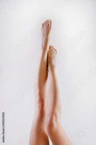 Cropped shot of woman's legs after body hair removal procedures. Unrecognizable woman showing her calves over isolated white background. Copy space for text, close up.