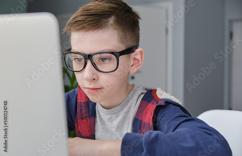Boy doing homework on laptop