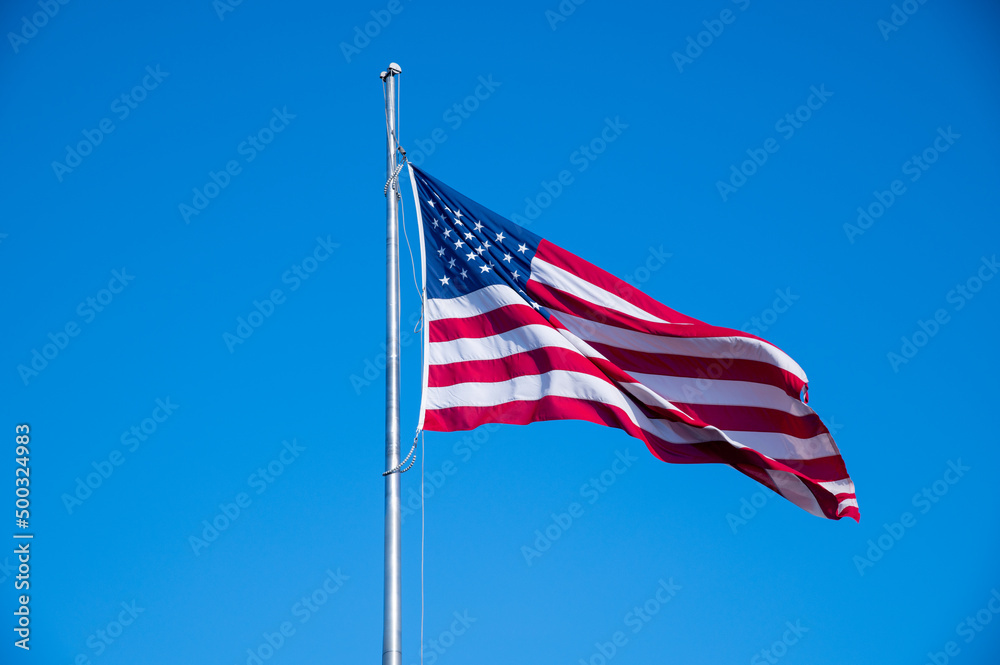American flag waving in blue sky American flag waving in blue sky