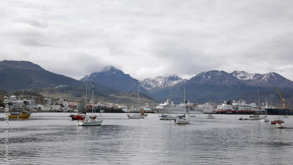 Panorama view of the bay in Ushuaia, Tierra del Fuego, Patagonia Argentina. View of the sailing boats, ships and cruisers in the Beagle Channel ocean with the Andes mountains in the background.