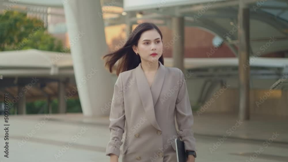 A young beautiful businesswoman is walking in Modern city , city lifestyle concept A young beautiful businesswoman is walking in Modern city , city lifestyle concept