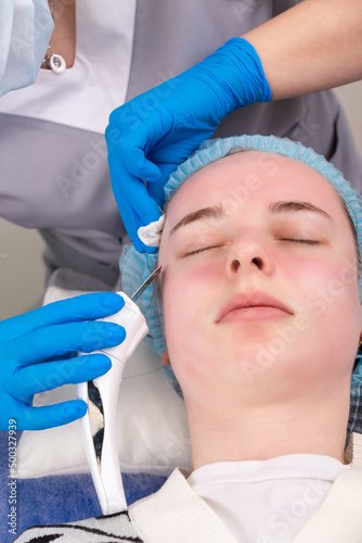 Young woman getting ultrasonic peel skin with skin scrubber.