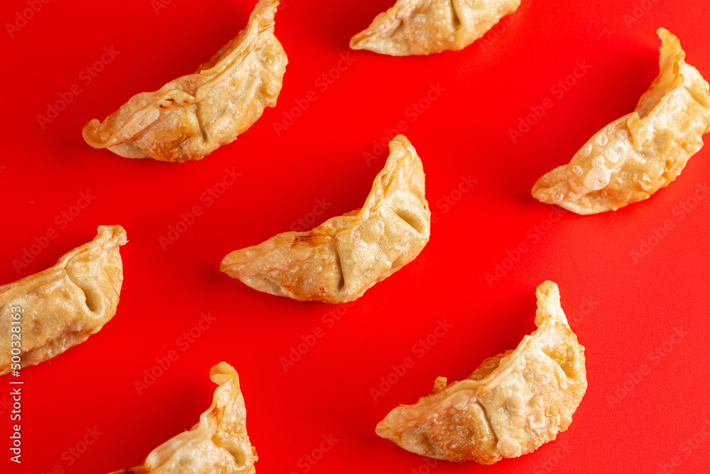 Fototapeta premium Background of Pork Potstickers Dumplings on a Bright Red Background