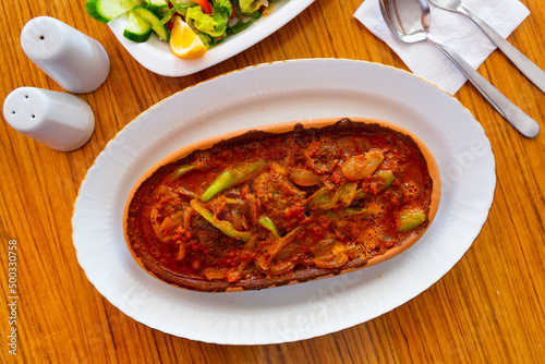 Spicy meatballs with vegetables and garlic in tomato sauce, popular dish of turkish and greek cuisine