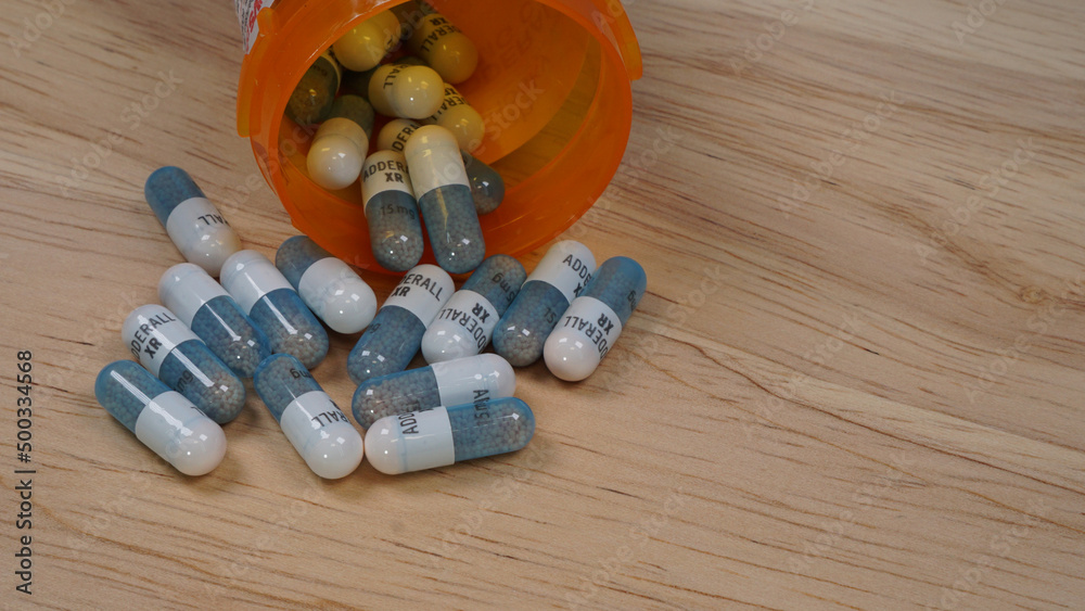 Prescription bottle with Adderall capsules. Adderall is used to treat