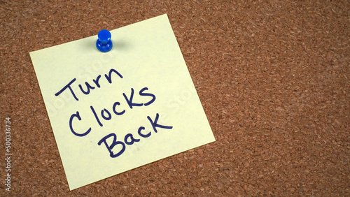 Note posted on a cork board with a reminder to turn clocks back at the end of Daylight Saving Time in November.