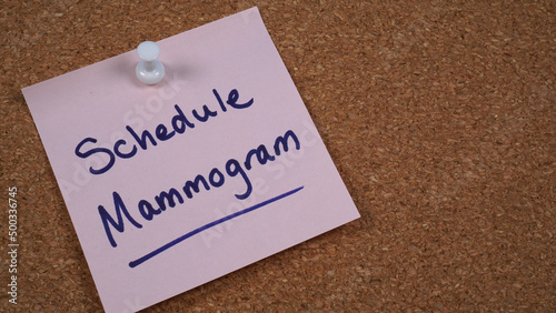 Note posted on a cork board with a reminder to schedule mammogram. October is Breast Cancer Awareness month.