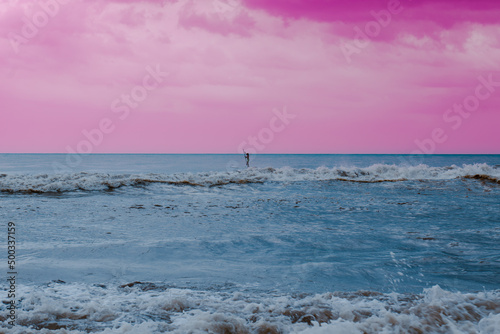 a blue sea and pink sky