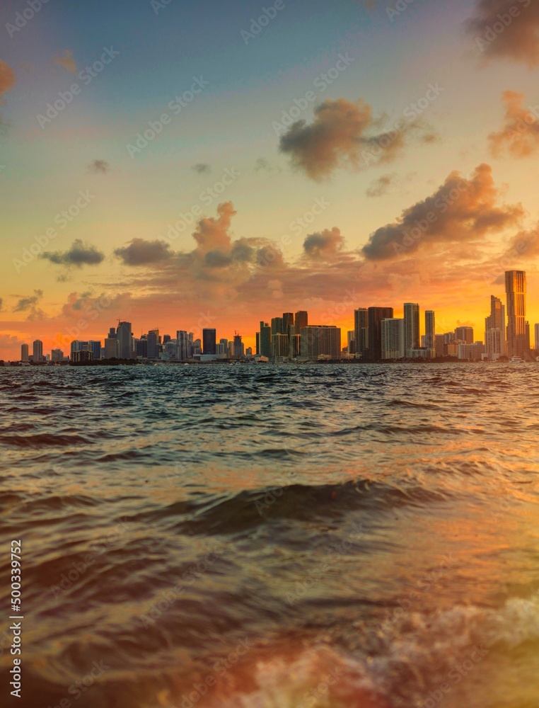 Obraz premium sunset sea water reflections sun miami skyline city
