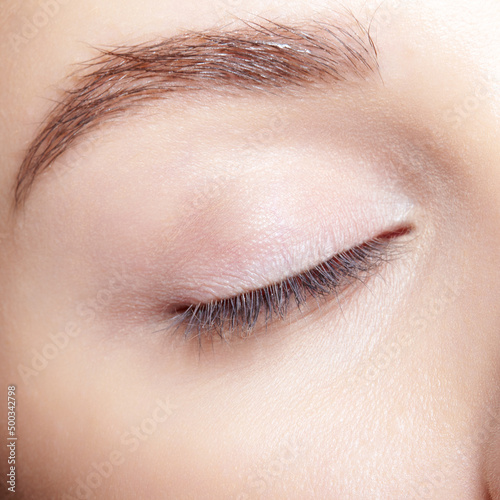 Closeup macro shot of human female closed eye with nude makeop.