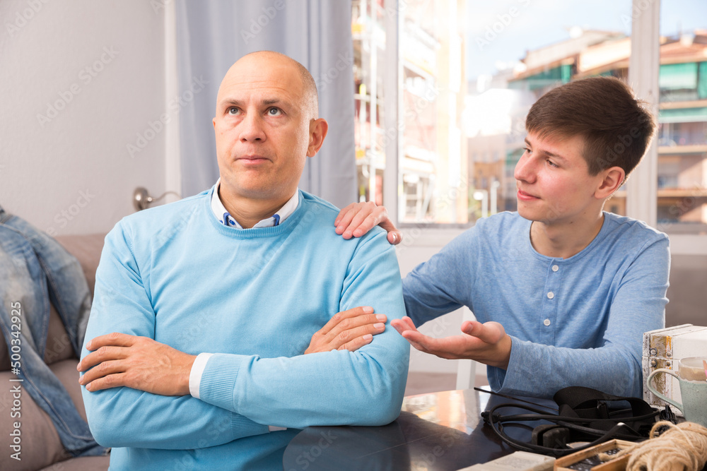 Obraz premium Teenage son asking for forgiveness from his offended father