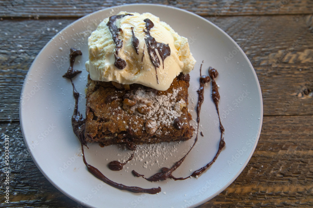 Top view of vanilla ice cream on a brownie on natural wood table Top view of vanilla ice cream on a brownie on natural wood table