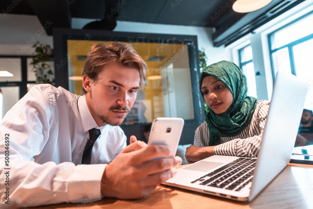 International multicultural business team.A young business man and woman sit in a modern relaxation space and talk about a new business. International multicultural business team.A young business man and woman sit in a modern relaxation space and talk about a new business.
