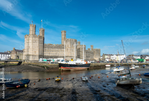 Caernarfon Castle and River Seiont at low tide,in late afternoon sun,North Wales,United Kingdom.