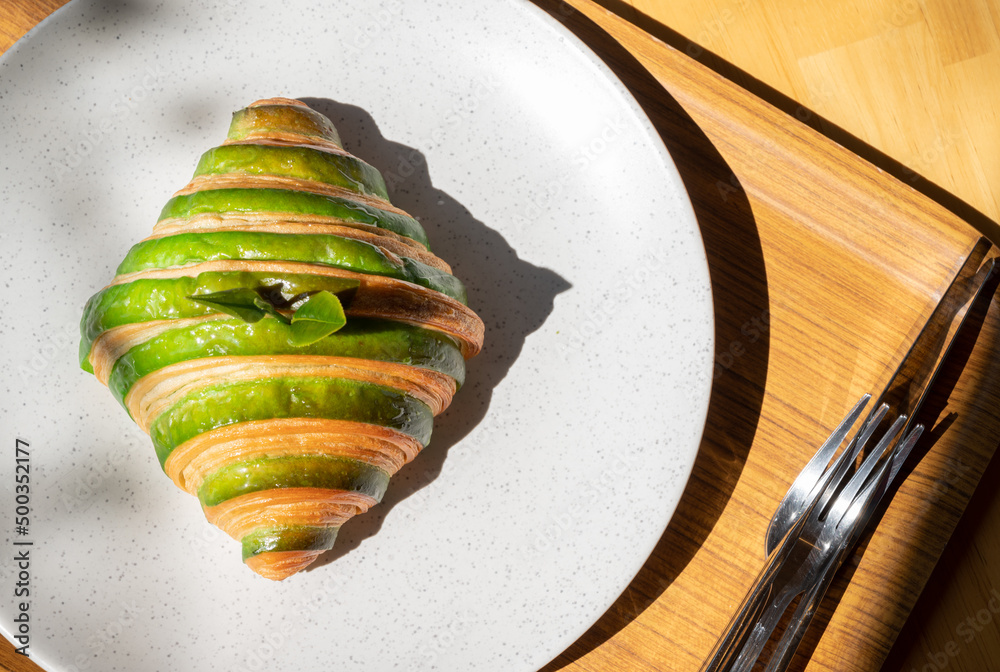 High angle view of Matcha (or green tea) croissant served with plate on