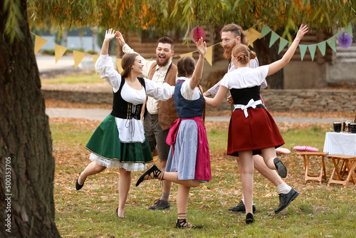 Drunk people dancing and celebrating Octoberfest outdoors photo