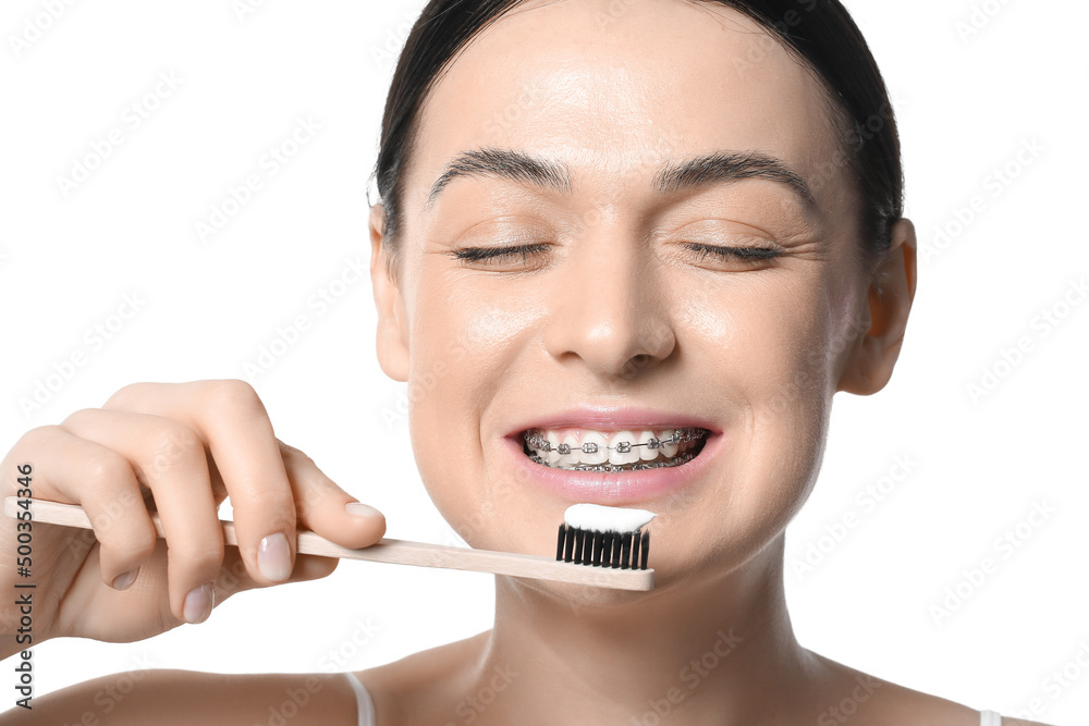Beautiful woman with dental braces and toothbrush on white background, closeup Beautiful woman with dental braces and toothbrush on white background, closeup