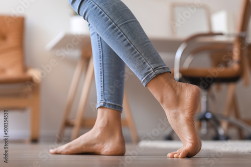 Bare feet of young woman walking at home, closeup © Pixel-Shot