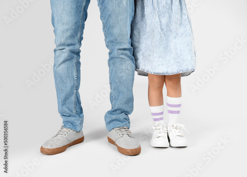 Little African-American girl and her father on grey background