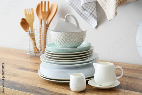 Beautiful dinnerware on kitchen counter near light wall