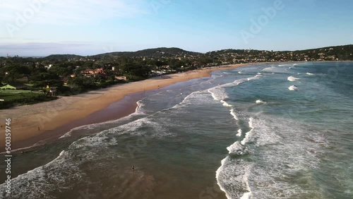 Aerial view of waves rolling into golden sand Geriba Beach in Buzios Brasil photo