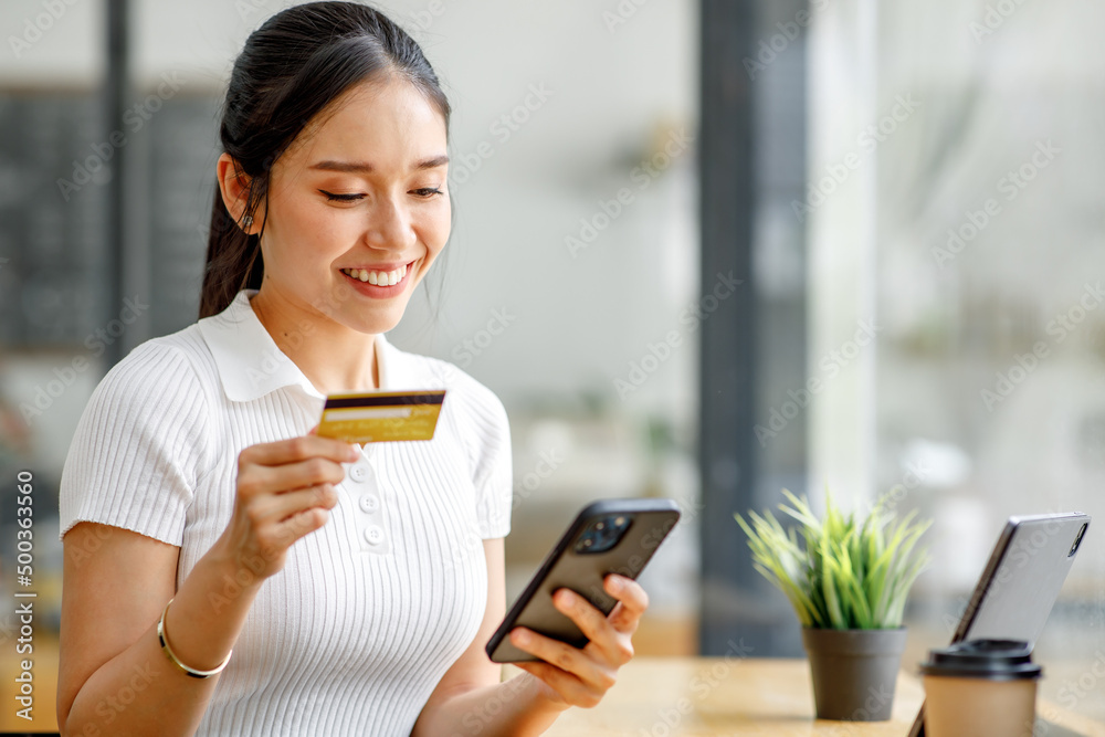 Women holding credit card and using tablet laptop computer at coffee shop.Online shopping, internet banking, store, payment, spending money, e-commerce payment at the store, credit card, concept Women holding credit card and using tablet laptop computer at coffee shop.Online shopping, internet banking, store, payment, spending money, e-commerce payment at the store, credit card, concept