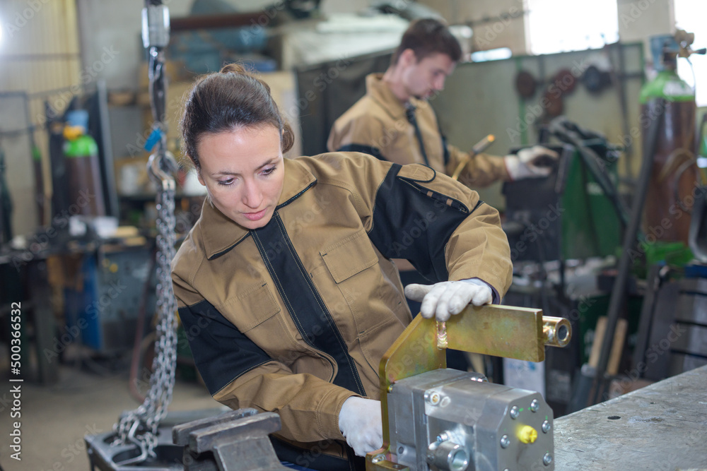 employees using industrial machinery at factory employees using industrial machinery at factory
