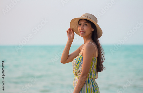 Woman wearing a straw hat and smiling. Portrait of a happy young woman with hat looking at camera with copy space.