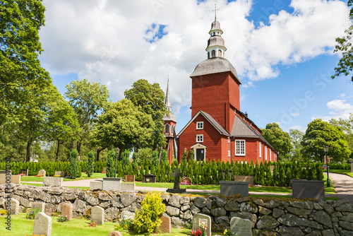 Cemetery with a red Wooden Church photo