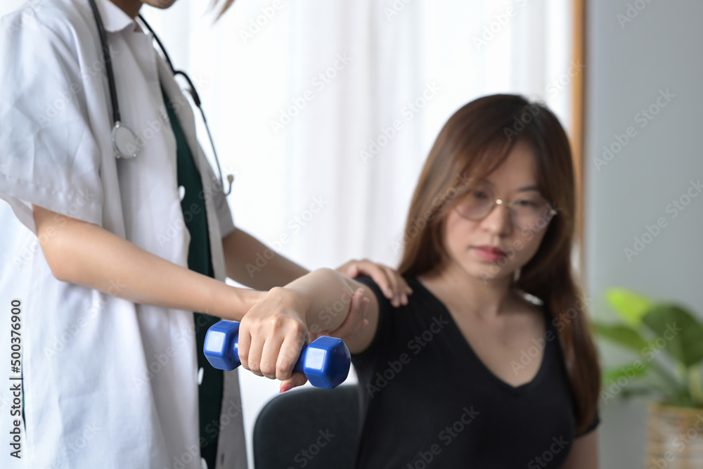 Obraz premium Physiotherapist examining, treating injured arm of female patient in clinic. Rehabilitation physiotherapy concept.