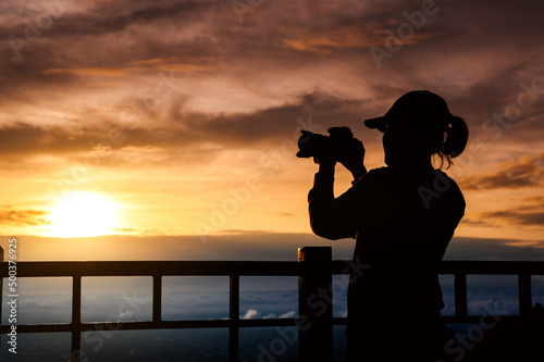 silhouette of woman taking picture with camera at sunrise on DOI SUTHEP mountain viewpoint, chiang mai, Thailand