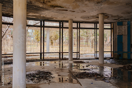 an old abandoned and ruined building with a wet ceiling and puddles on the floor