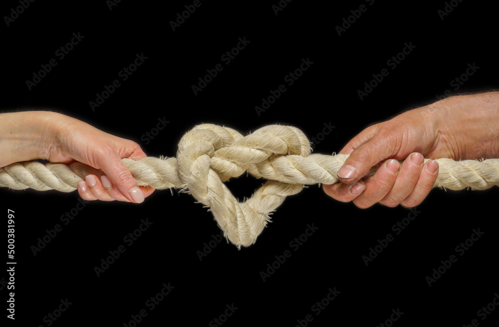 Image of a heart in the form of a rope knot. Male and female hands