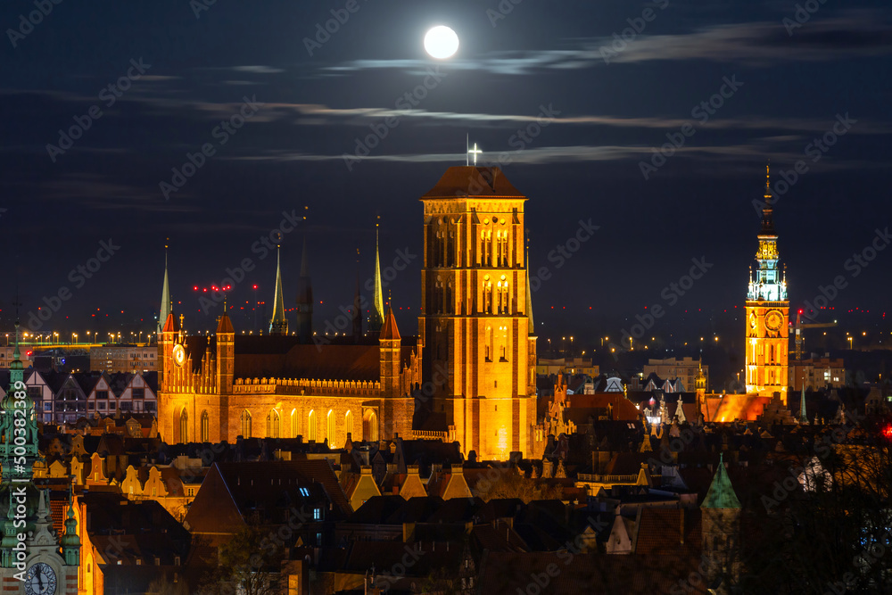 A full moon rising over the city of Gdansk at night. Poland