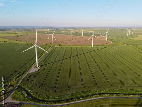 Aerial drone. Wind farm in the fields in south east England. Wind turbines near Camber Sands and Rye, East Sussex.