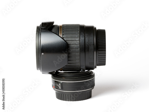 Photographic equipment, photo lenses. Two lenses one lies on top of the other. Big and small, Zoom and fix. On a white background side view photo