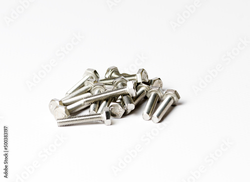A handful of bolts with shiny metal threads on a white background side view