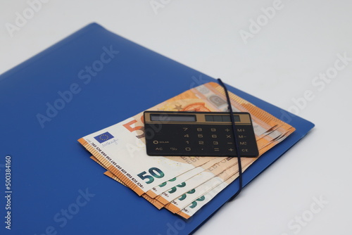 Calculator and banknotes lie on a folder for papers, financial accounting and control. photo