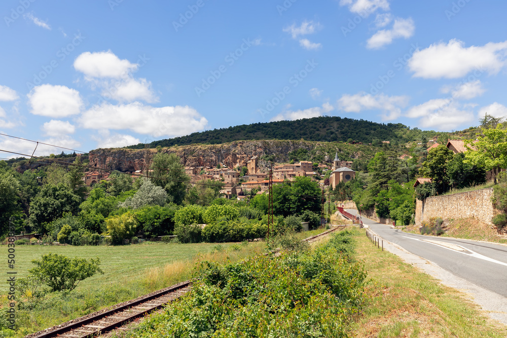 View of Peyre village, Church of St. Christopher and old railroad track from country road D41. Compregnac, Aveyron, France  (Causse du Larzac)