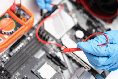 Engineer is testing motherboard chip repair closeup