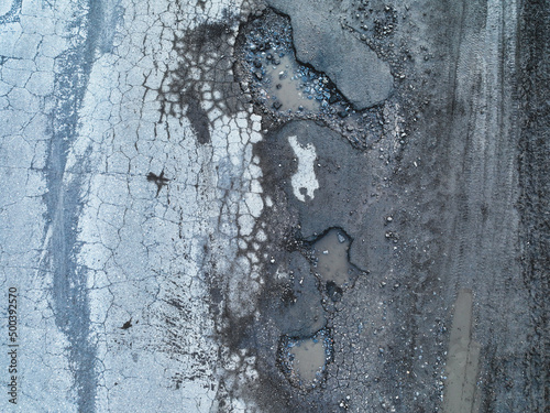 Wallpaper Mural Broken old asphalt road outside the city. Pits and potholes. Aerial view Torontodigital.ca